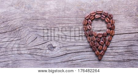 geolocation tag gps  from coffee beans on old wooden table. empty space for text