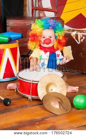 Little baby clown with red nose multi-colored wig in with balls.