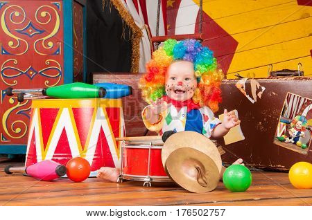 Little baby clown with red nose multi-colored wig in with balls.