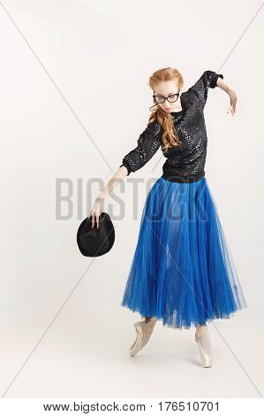 Lovely ballerina hipster in a ballet tutu and pointe dance with a hat. Modern dance.