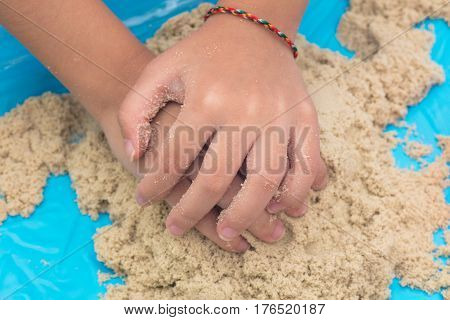 Child's Hand Close Up Playing Kinetic Sand