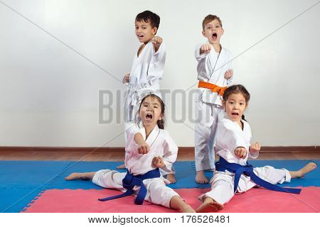 Four children demonstrate martial arts working together. Fighting position active lifestyle expressing emotions