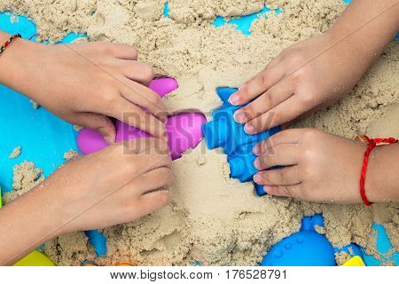 Childs Hand Close Up Playing Kinetic Sand