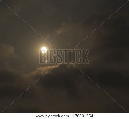 Sun shine in dark cloudy sky background.