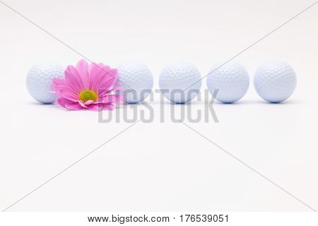 White golf balls and sping flower on the white table