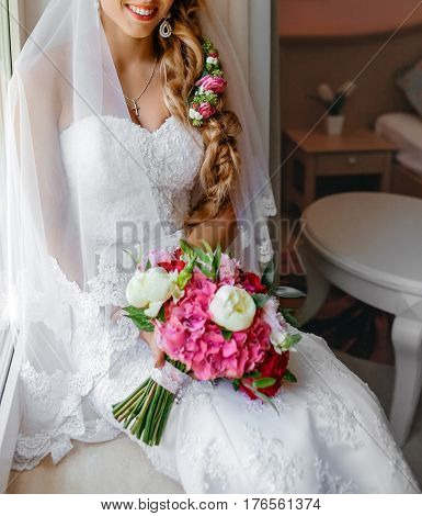 Bride holding delicate and tender marriage bouquet in white and pink colours with green petals