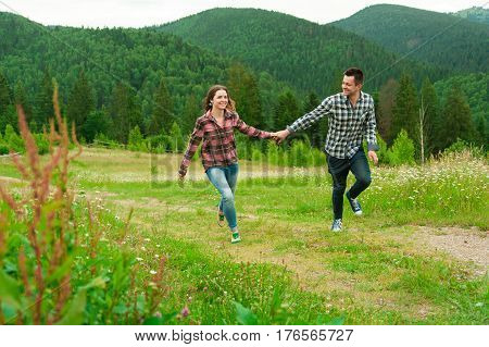 Loving couple having fun on summer vacation. Portrait of a happy couple laughing. Summer holidays love relationship concept - smiling couple in mountaines. Couple outdoors