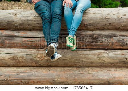 Male and female legs in keds and jeans. Stylish couple feet in love their legs