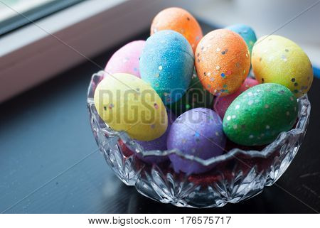 Easter Eggs In Crystal Dishes On A Black Wooden Background,