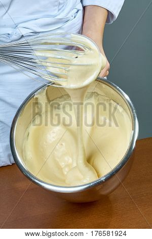 chef whips yellow cream in a bowl by hand for making cheesecakes complete series of food recipes