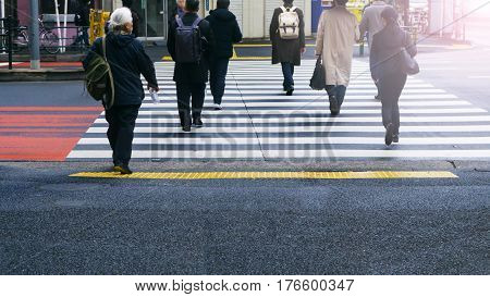 business and worker people walk on pedestrian crosswalk at the junction street of city with the white and yellow symbol signage traffic (bottom view)