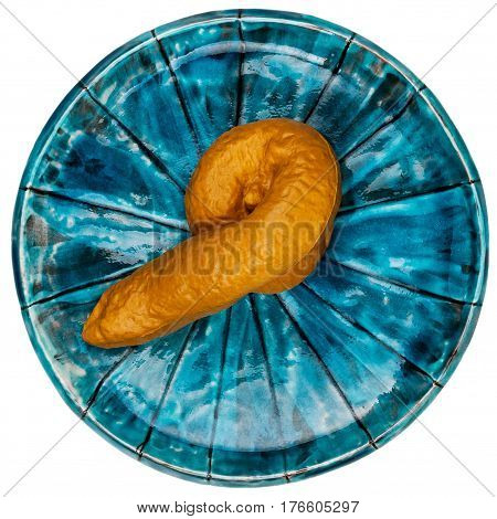 Fake rubber excrement in a plate isolated on white background