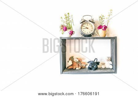 small doll and clock with flower pot decoration on wood frame isolated white background