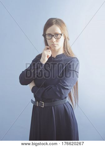 A woman with glasses and a strict dress.