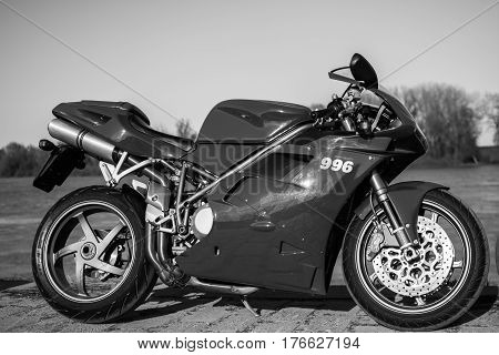Senta Serbia: March 4th 2017. Closeup of beautiful red Ducati 996s motorcycle photographed outdoor on a dock in Senta besides beautiful painted wall under the bridge.