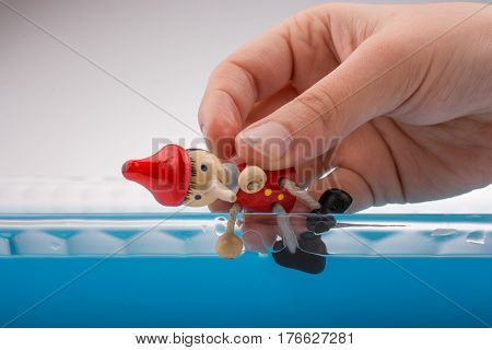 Hand Holding Pinocchio On In  Water