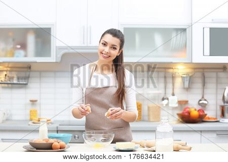 Beautiful young woman cooking in kitchen