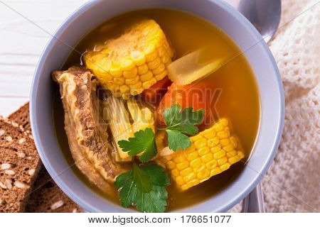 Puchero Soup With Corn And Parsley On Wooden Table