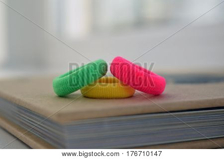 Colorful scrunchies (green yellow red) on book background