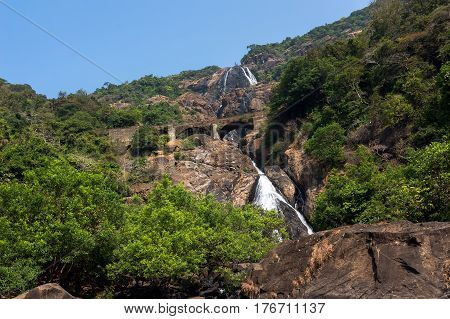 waterfall in the mountains among the green trees in the jungle. India.