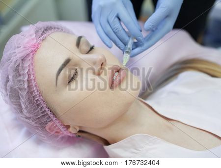 Woman gets injection in her face. Beauty woman giving injections. Young woman gets beauty facial injections in the cosmetology salon. Face aging injection. Aesthetic Medicine, Cosmetology
