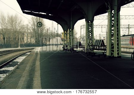 Platform clock and benches without people and no train