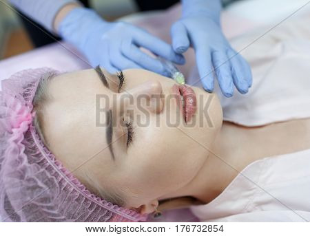Woman gets injection in her face. Beauty woman giving injections. Young woman gets beauty facial injections in the cosmetology salon. Face aging injection. Aesthetic Medicine, Cosmetology