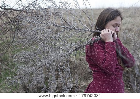 girl in the red folk dress gathers dry grass