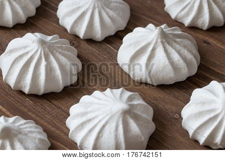 Mini meringues on a wooden background. Close up