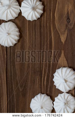 Fresh mini meringues on wooden background. Top view