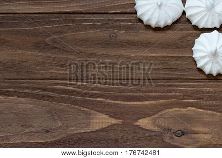 Several fresh mini meringues on a wooden background
