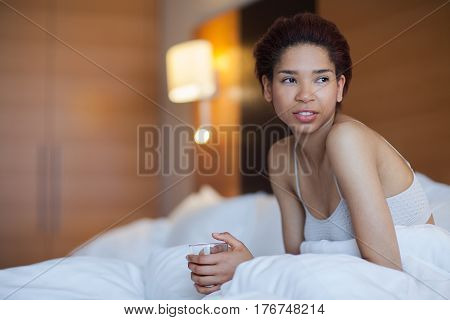 Young Happy Black Woman Sits In A Bed.