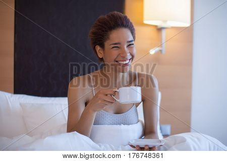 Young Happy Black Woman Sits In A Bed.