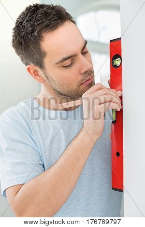 Mid-adult man marking on wall with level