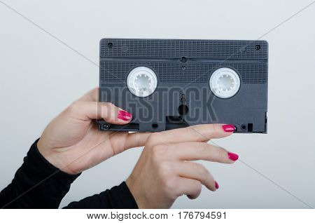 woman hands with an old cassette from a videorecorder