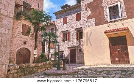 Kotor narrow small streets of historical old town. House drying linen bright sun blind old stone. Authentic structures. No body tourists.