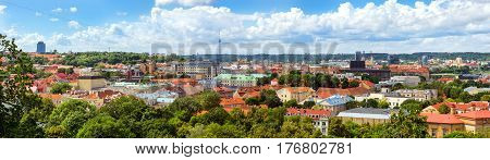 Panorama of Vilnius from top of mountain of Gediminas Tower. Red rooftops of old town & modern business building of glass and concrete. On horizon is television tower. Lithuania