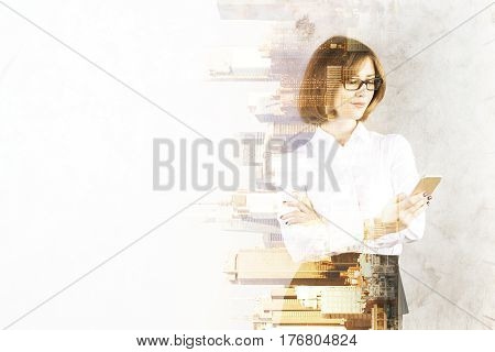 Portrait of attractive young woman using smartphone on abstract sideways city background with copy space and sunlight. Double exposure