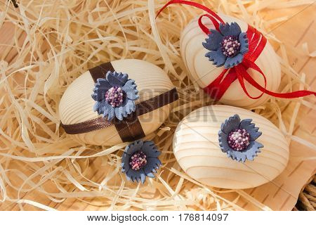 Easter eggs with ribbon and blue  flowers. Background birch bark and straw