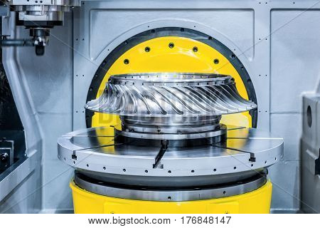 The CNC milling machine processes the turbine wheel. Abstract industrial background.