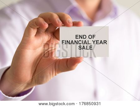 Businessman Holding A Card With End Of Financial Year Sale Message
