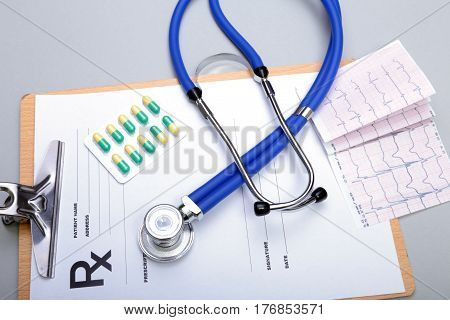 RX prescription, Red heart, asorted pils and a stethoscope on white background.