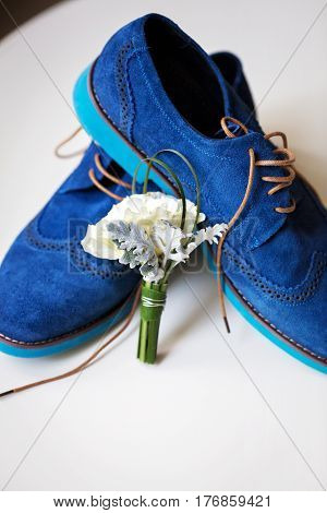 Pair of elegant grooms blue suede brogue shoes with tenderless boutonniere