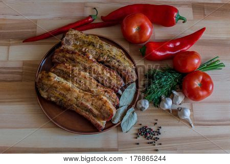 Grilled pork chop with bay leaf pepper garlic and dill on wooden board - selective focus food background