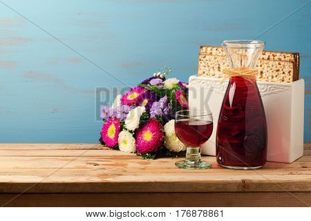 Jewish Passover holiday Pesah celebration concept with matzoh wine and flowers over blue background