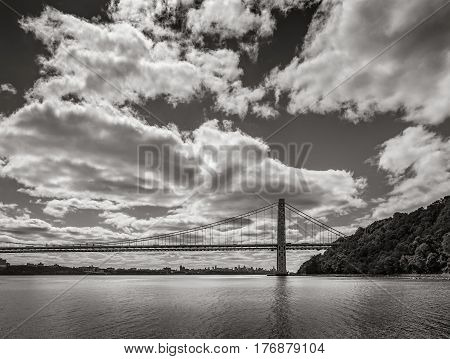 George Washington Bridge spanning Hudson River with clouds in Black & White. New York City