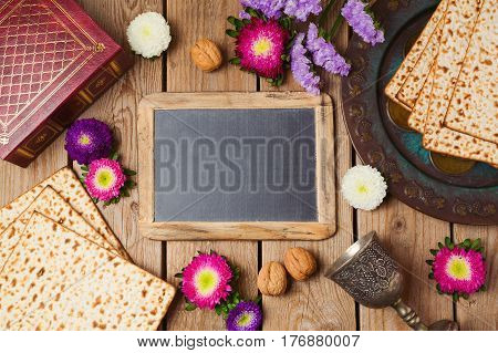 Jewish holiday Passover background with chalkboard matza and seder plate. View from above