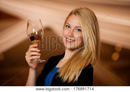 Beautiful Young Blond Woman Drinks Wine In Wine Cellar
