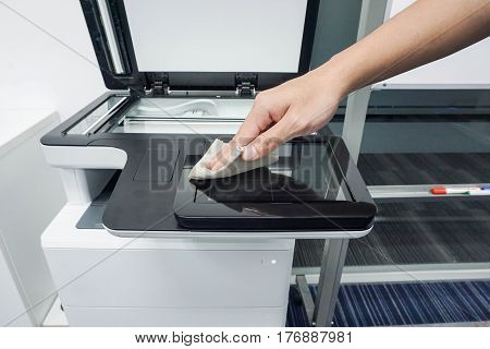 close up businessman clean touch screen of office printer for maintenance
