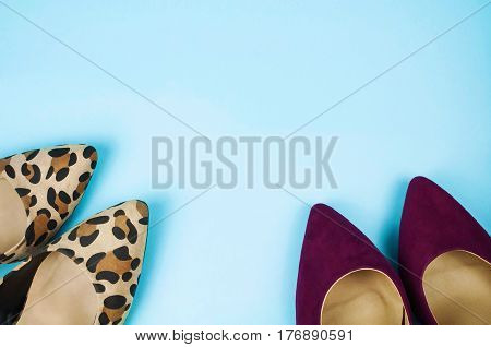 Two pairs of multicoloured stiletto shoes in different patterns on light blue background.